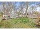 Fenced backyard with colorful wall art, grass, and mature trees at 5028 Graceland Ave, Indianapolis, IN 46208