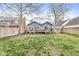 Backyard featuring wooden deck, lush grass, and mature trees at 5028 Graceland Ave, Indianapolis, IN 46208