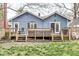Spacious backyard with large wooden deck, seating, and mature trees at 5028 Graceland Ave, Indianapolis, IN 46208