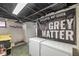 Unfinished basement with concrete floor, exposed ceiling, and 'Grey Matter' graphic on wall at 5028 Graceland Ave, Indianapolis, IN 46208