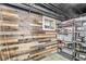 Finished basement with wood-paneled wall, small window, and organized shelving units at 5028 Graceland Ave, Indianapolis, IN 46208