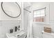 Bright bathroom with white subway tile shower and a round mirror above the sink at 5028 Graceland Ave, Indianapolis, IN 46208