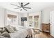 Bright bedroom with French doors, ceiling fan, hardwood floors, and two windows at 5028 Graceland Ave, Indianapolis, IN 46208