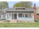 Inviting home with a covered porch, classic architecture, and a well-manicured lawn at 5028 Graceland Ave, Indianapolis, IN 46208