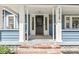 Close-up of a covered front porch featuring a black door and decorative columns at 5028 Graceland Ave, Indianapolis, IN 46208