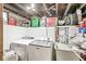 Basement laundry room with Maytag washer/dryer, utility sink, and shelving for storage at 5028 Graceland Ave, Indianapolis, IN 46208
