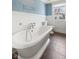 Bathroom featuring a soaking tub, tile flooring, and blue walls at 5116 Norway Dr, Indianapolis, IN 46219