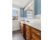 Bathroom with blue walls, a window, and vanity with wood cabinetry at 5116 Norway Dr, Indianapolis, IN 46219