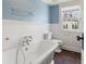 Bathroom featuring a soaking tub, tile flooring, and blue walls at 5116 Norway Dr, Indianapolis, IN 46219