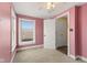 Bedroom featuring pink walls, a window and closet space, with light carpeting at 5116 Norway Dr, Indianapolis, IN 46219