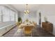 Elegant dining room with a vintage chandelier, wainscoting, and bright windows, perfect for entertaining guests at 5116 Norway Dr, Indianapolis, IN 46219