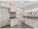 Well-lit kitchen with white cabinets, a stainless steel dishwasher, and ample countertop space, perfect for cooking at 5116 Norway Dr, Indianapolis, IN 46219