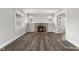 Cozy living room featuring a charming fireplace and an open doorway, complemented by stylish wood flooring at 5116 Norway Dr, Indianapolis, IN 46219