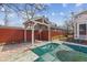 Backyard features a brick patio with a covered pool, enclosed by a red fence at 5116 Norway Dr, Indianapolis, IN 46219