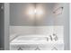 Relaxing bathroom featuring a large soaking tub with tiled surround and updated fixtures at 5367 Cotton Bay W Dr, Indianapolis, IN 46254