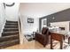 Cozy living area featuring a plush sofa, fireplace, and staircase at 5367 Cotton Bay W Dr, Indianapolis, IN 46254