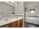 Bathroom with double sink vanity, large mirror, soaking tub, and tile accents at 5426 Black Bear Cir, Indianapolis, IN 46239