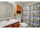 Well-maintained bathroom with oak cabinets, a mirror, and a charming lighthouse-themed shower curtain at 5426 Black Bear Cir, Indianapolis, IN 46239
