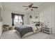 This staged bedroom is brightly lit by a window with a ceiling fan and comfortable decor at 5426 Black Bear Cir, Indianapolis, IN 46239