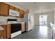 Efficient kitchen with white refrigerator, wood cabinets, black oven/stove and eat-in dining area beyond at 5426 Black Bear Cir, Indianapolis, IN 46239