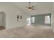 Bright living room with carpet, featuring a vaulted ceiling with a fan, and view to kitchen at 5426 Black Bear Cir, Indianapolis, IN 46239