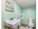 Small bathroom features a sink and toilet with visible wall damage, needs renovation at 5734 Hillside Ave, Indianapolis, IN 46220