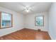Bright bedroom with hardwood floors, a ceiling fan, and two windows offering natural light at 5734 Hillside Ave, Indianapolis, IN 46220