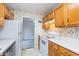 Traditional kitchen featuring wooden cabinetry, white appliances, and a floral wallpaper design at 5734 Hillside Ave, Indianapolis, IN 46220