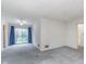 Large carpeted living area with a glass door to the backyard and neutral walls at 5734 Hillside Ave, Indianapolis, IN 46220