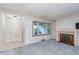 Bright living room with a painted brick fireplace, large windows, and neutral carpeting at 5734 Hillside Ave, Indianapolis, IN 46220