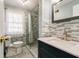 A renovated bathroom with a glass shower, modern vanity, and decorative tile at 6047 W 56Th St, Indianapolis, IN 46254