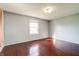 A neutral bedroom with hardwood floors, a window, and painted walls at 6047 W 56Th St, Indianapolis, IN 46254