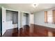 A bedroom with hardwood flooring, painted walls, and a double door closet at 6047 W 56Th St, Indianapolis, IN 46254
