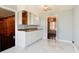 Kitchen features white cabinets, marble floors, and connection to dining area at 6047 W 56Th St, Indianapolis, IN 46254