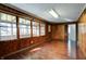 Cozy room with rich hardwood flooring, classic wood paneling, and an abundance of natural light at 6047 W 56Th St, Indianapolis, IN 46254