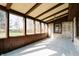Well-lit sunroom with tile flooring, rustic walls, and expansive windows providing a great view of the backyard at 6047 W 56Th St, Indianapolis, IN 46254