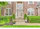 Close-up of a home's front door with elegant trim, decorative plants, and a manicured garden at 6071 Sugar Pine Dr, Avon, IN 46123