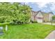 Well-manicured front yard with mature trees and lush green grass surrounding a brick home at 6071 Sugar Pine Dr, Avon, IN 46123