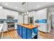 A modern kitchen with white cabinets, stainless steel appliances, and blue backsplash and kitchen island at 6071 Sugar Pine Dr, Avon, IN 46123