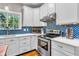 A modern kitchen features white cabinets, stainless steel appliances, and a blue patterned backsplash at 6071 Sugar Pine Dr, Avon, IN 46123