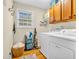 Efficient laundry room with washer, dryer, storage cabinets, and a window for ventilation at 6071 Sugar Pine Dr, Avon, IN 46123