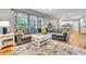 Spacious living area with a comfortable gray sofa, large windows and hardwood flooring at 6071 Sugar Pine Dr, Avon, IN 46123