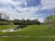 Scenic view of a community pond surrounded by mature trees and lush green grass at 6071 Sugar Pine Dr, Avon, IN 46123