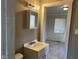 Cozy bathroom featuring a vanity, mirror, and view into a sunlit bedroom at 635 Laclede St, Indianapolis, IN 46241