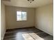 Vacant bedroom with wood-look flooring, a gray rug, and a window view at 635 Laclede St, Indianapolis, IN 46241