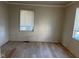 Bright empty bedroom featuring light wood floors, blinds, and neutral walls at 635 Laclede St, Indianapolis, IN 46241
