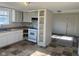A kitchen area offers white cabinetry and an opening to another room, with wood-look vinyl flooring at 635 Laclede St, Indianapolis, IN 46241