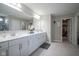 Bathroom with a double vanity, a mirror, tile floor and a view into the walk-in closet at 7140 Leatherwood Dr, Indianapolis, IN 46259