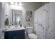 Well-lit bathroom with marble-design shower curtain, navy blue vanity with white sink, and neutral decor at 7140 Leatherwood Dr, Indianapolis, IN 46259