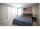 Inviting bedroom featuring a gray headboard bed, American flag, and white closet doors, creating a cozy space at 7140 Leatherwood Dr, Indianapolis, IN 46259